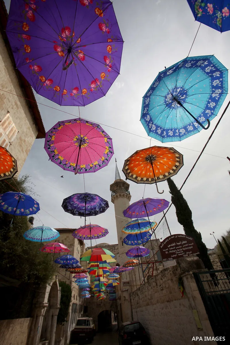 A picture taken on March 13, 2016 shows umbrellas used to decorate a street in the old city of Nablus, in the occupied West Bank. Photo by Nedal Eshtayah