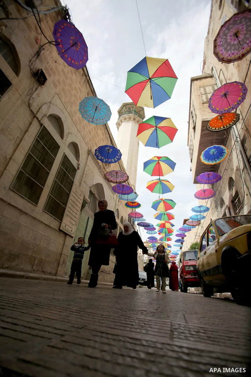 A picture taken on March 13, 2016 shows umbrellas used to decorate a street in the old city of Nablus, in the occupied West Bank. Photo by Nedal Eshtayah
