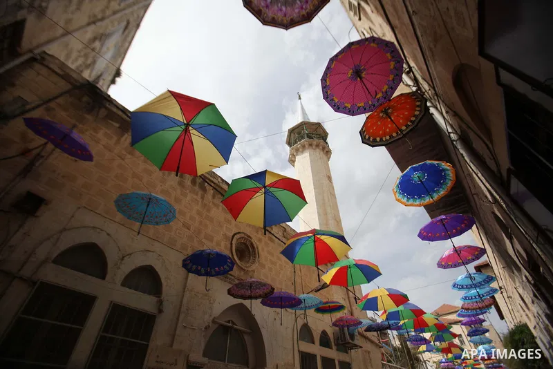 A picture taken on March 13, 2016 shows umbrellas used to decorate a street in the old city of Nablus, in the occupied West Bank. Photo by Nedal Eshtayah