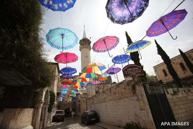 A picture taken on March 13, 2016 shows umbrellas used to decorate a street in the old city of Nablus, in the occupied West Bank. Photo by Nedal Eshtayah