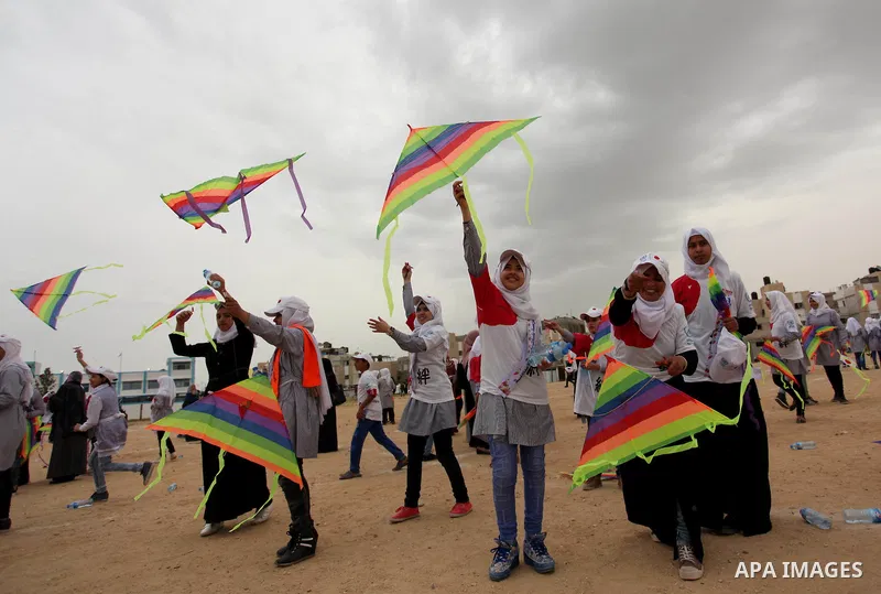Palestinian children fly kites to show their solidarity with the Japanese people near the Japan-funded housing project in Khan Younis in the southern Gaza Strip March 13, 2016. The event was organised by the United Natio...