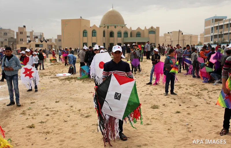 Palestinian children fly kites to show their solidarity with the Japanese people near the Japan-funded housing project in Khan Younis in the southern Gaza Strip March 13, 2016. The event was organised by the United Natio...