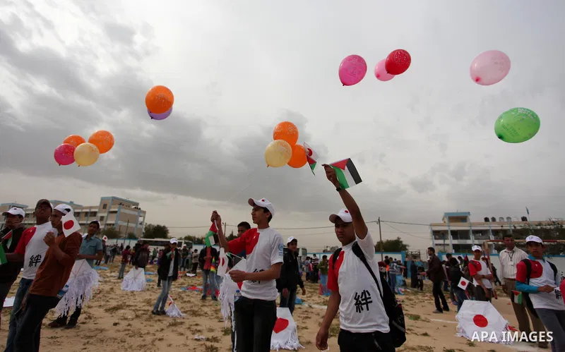Palestinian children fly kites to show their solidarity with the Japanese people near the Japan-funded housing project in Khan Younis in the southern Gaza Strip March 13, 2016. The event was organised by the United Natio...
