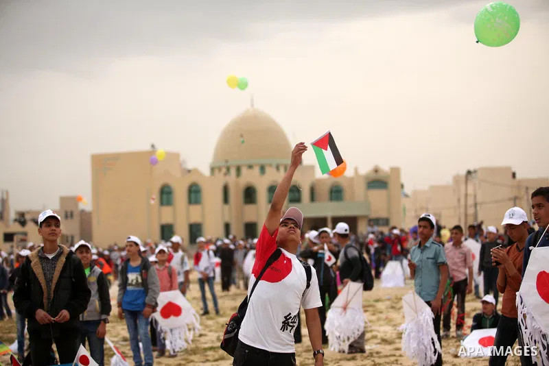 Palestinian children fly kites to show their solidarity with the Japanese people near the Japan-funded housing project in Khan Younis in the southern Gaza Strip March 13, 2016. The event was organised by the United Natio...