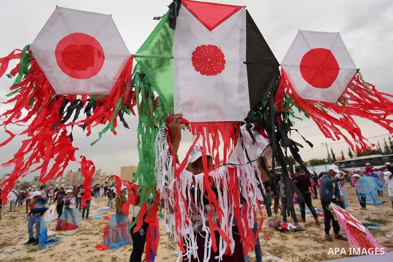 Palestinian children fly kites to show their solidarity with the Japanese people near the Japan-funded housing project in Khan Younis in the southern Gaza Strip March 13, 2016. The event was organised by the United Natio...