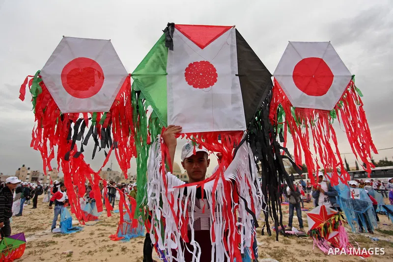 Palestinian children fly kites to show their solidarity with the Japanese people near the Japan-funded housing project in Khan Younis in the southern Gaza Strip March 13, 2016. The event was organised by the United Natio...
