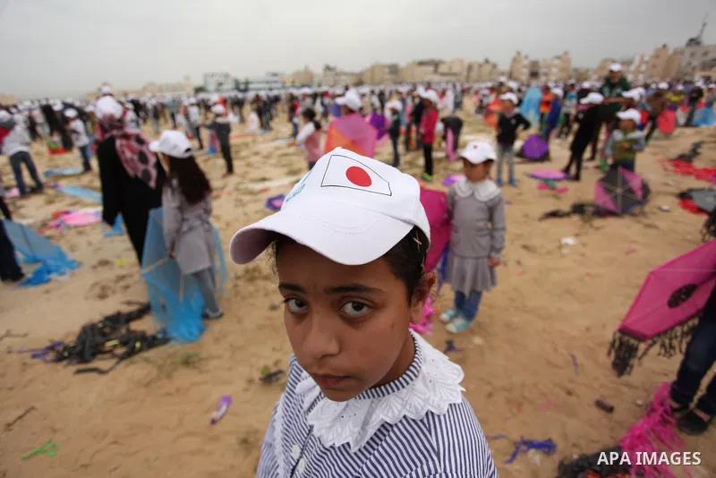 Palestinian children fly kites to show their solidarity with the Japanese people near the Japan-funded housing project in Khan Younis in the southern Gaza Strip March 13, 2016. The event was organised by the United Natio...