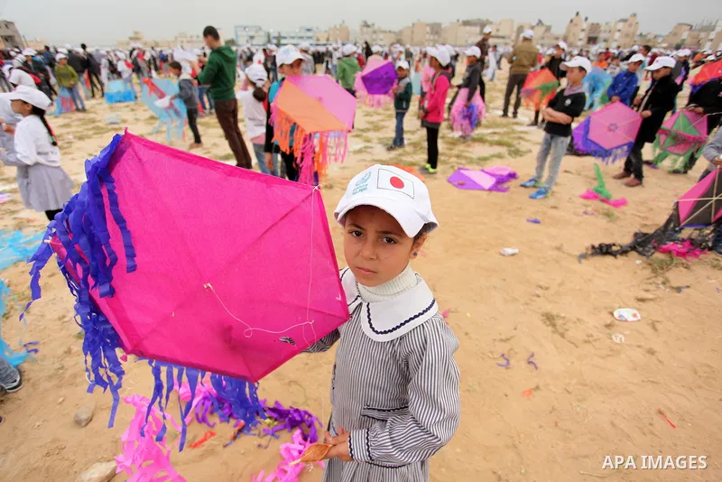 Palestinian children fly kites to show their solidarity with the Japanese people near the Japan-funded housing project in Khan Younis in the southern Gaza Strip March 13, 2016. The event was organised by the United Natio...