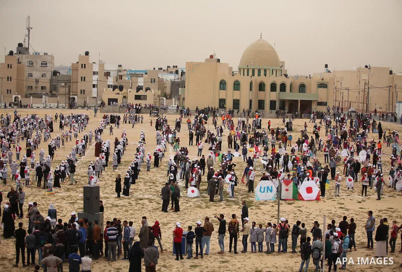 Palestinian children fly kites to show their solidarity with the Japanese people near the Japan-funded housing project in Khan Younis in the southern Gaza Strip March 13, 2016. The event was organised by the United Natio...