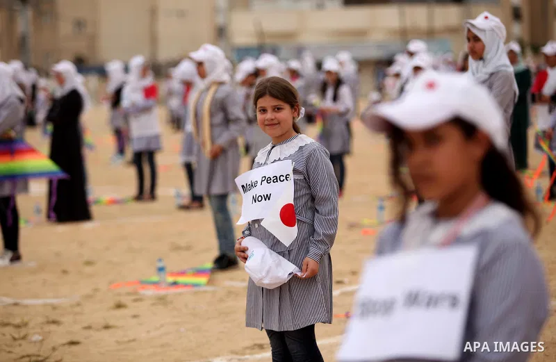 Palestinian children fly kites to show their solidarity with the Japanese people near the Japan-funded housing project in Khan Younis in the southern Gaza Strip March 13, 2016. The event was organised by the United Natio...