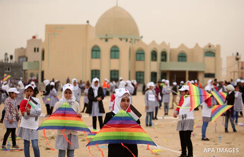 Palestinian children fly kites to show their solidarity with the Japanese people near the Japan-funded housing project in Khan Younis in the southern Gaza Strip March 13, 2016. The event was organised by the United Natio...