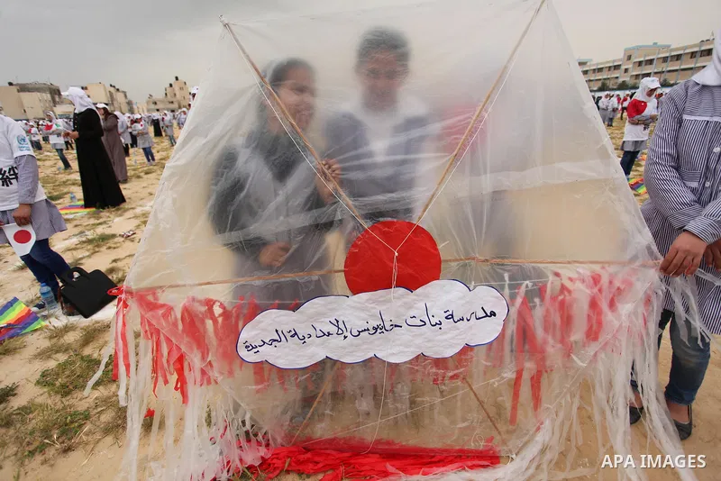 Palestinian children fly kites to show their solidarity with the Japanese people near the Japan-funded housing project in Khan Younis in the southern Gaza Strip March 13, 2016. The event was organised by the United Natio...