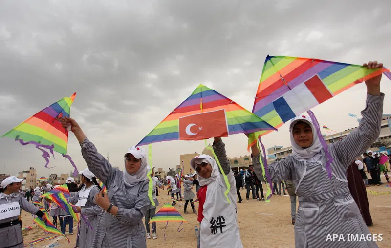 Palestinian children fly kites to show their solidarity with the Japanese people near the Japan-funded housing project in Khan Younis in the southern Gaza Strip March 13, 2016. The event was organised by the United Natio...