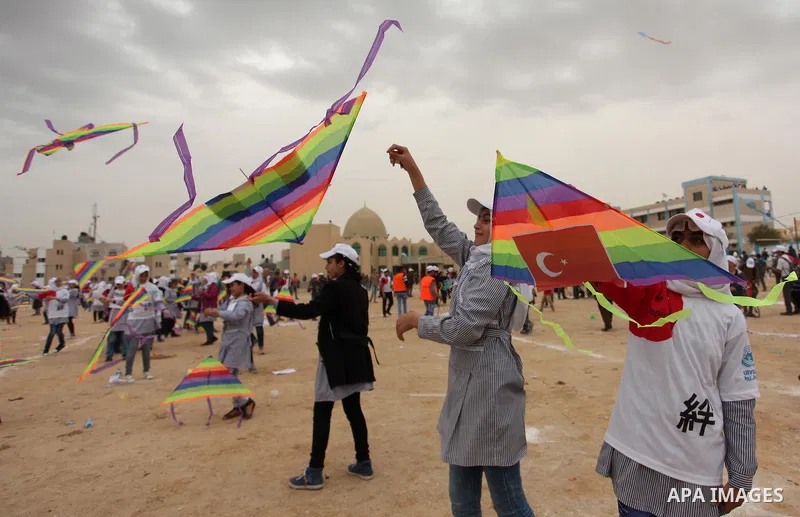 Palestinian children fly kites to show their solidarity with the Japanese people near the Japan-funded housing project in Khan Younis in the southern Gaza Strip March 13, 2016. The event was organised by the United Natio...