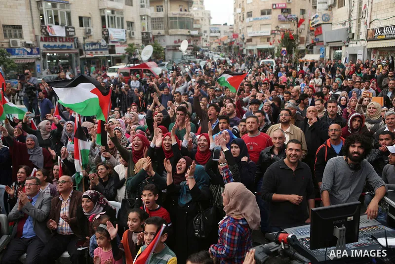 Palestinians celebrate in the West Bank city of Ramallah March 13, 2016 after primary school teacher Hanan al-Hroub won the Million Dollar Teacher award. Al-Hroub travelled from the West Bank to Dubai, where on Sunday th...