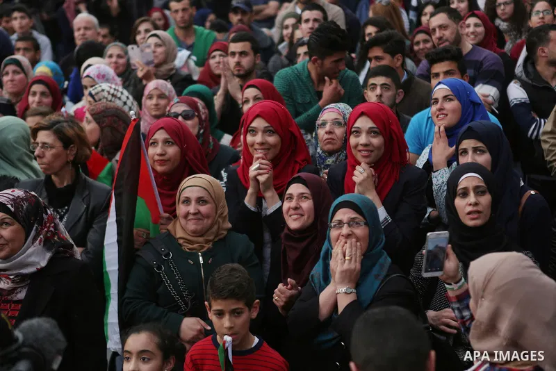 Palestinians celebrate in the West Bank city of Ramallah March 13, 2016 after primary school teacher Hanan al-Hroub won the Million Dollar Teacher award. Al-Hroub travelled from the West Bank to Dubai, where on Sunday th...