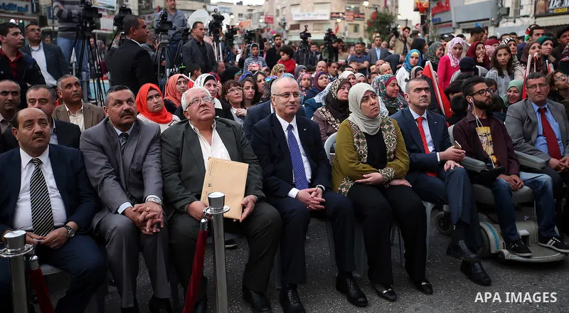 Palestinian Prime Minister, celebrates in the West Bank city of Ramallah March 13, 2016 after primary school teacher Hanan al-Hroub won the Million Dollar Teacher award. Al-Hroub travelled from the West Bank to Dubai, wh...