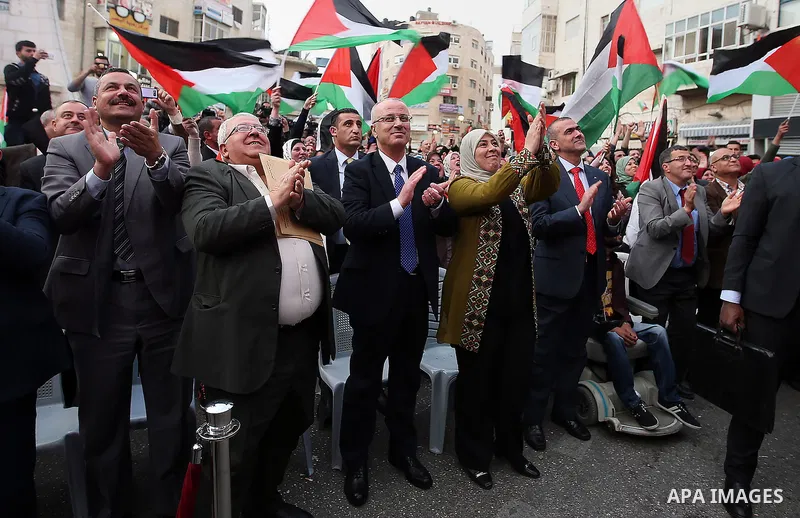 Palestinian Prime Minister, celebrates in the West Bank city of Ramallah March 13, 2016 after primary school teacher Hanan al-Hroub won the Million Dollar Teacher award. Al-Hroub travelled from the West Bank to Dubai, wh...