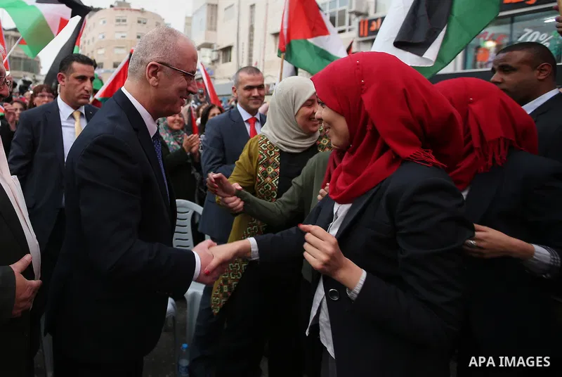 Palestinian Prime Minister, celebrates in the West Bank city of Ramallah March 13, 2016 after primary school teacher Hanan al-Hroub won the Million Dollar Teacher award. Al-Hroub travelled from the West Bank to Dubai, wh...