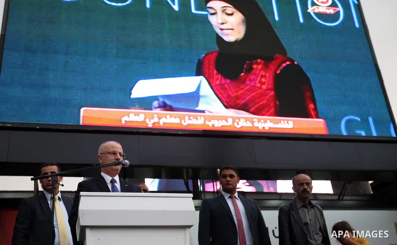 Palestinian Prime Minister, celebrates in the West Bank city of Ramallah March 13, 2016 after primary school teacher Hanan al-Hroub won the Million Dollar Teacher award. Al-Hroub travelled from the West Bank to Dubai, wh...
