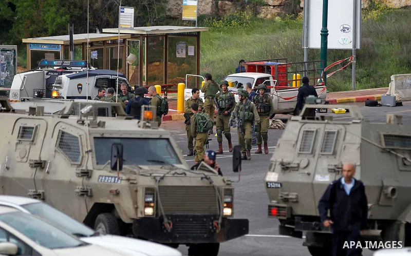 Israeli security forces gather at the scene of what the Israeli military said were back-to-back gun and car-ramming attacks by Palestinians, near the Jewish settlement of Kiryat Arba near the West Bank city of Hebron Mar...