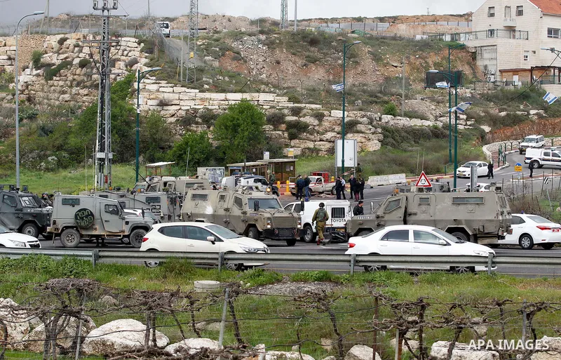 Israeli security forces gather at the scene of what the Israeli military said were back-to-back gun and car-ramming attacks by Palestinians, near the Jewish settlement of Kiryat Arba near the West Bank city of Hebron Mar...