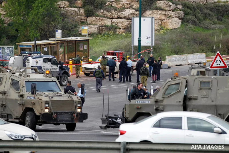 Israeli security forces gather at the scene of what the Israeli military said were back-to-back gun and car-ramming attacks by Palestinians, near the Jewish settlement of Kiryat Arba near the West Bank city of Hebron Mar...