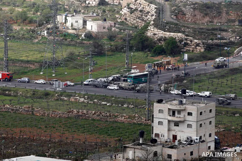 Israeli security forces gather at the scene of what the Israeli military said were back-to-back gun and car-ramming attacks by Palestinians, near the Jewish settlement of Kiryat Arba near the West Bank city of Hebron Mar...