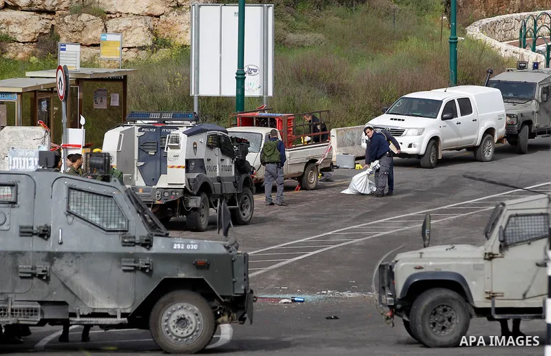 Israeli security forces gather at the scene of what the Israeli military said were back-to-back gun and car-ramming attacks by Palestinians, near the Jewish settlement of Kiryat Arba near the West Bank city of Hebron Mar...
