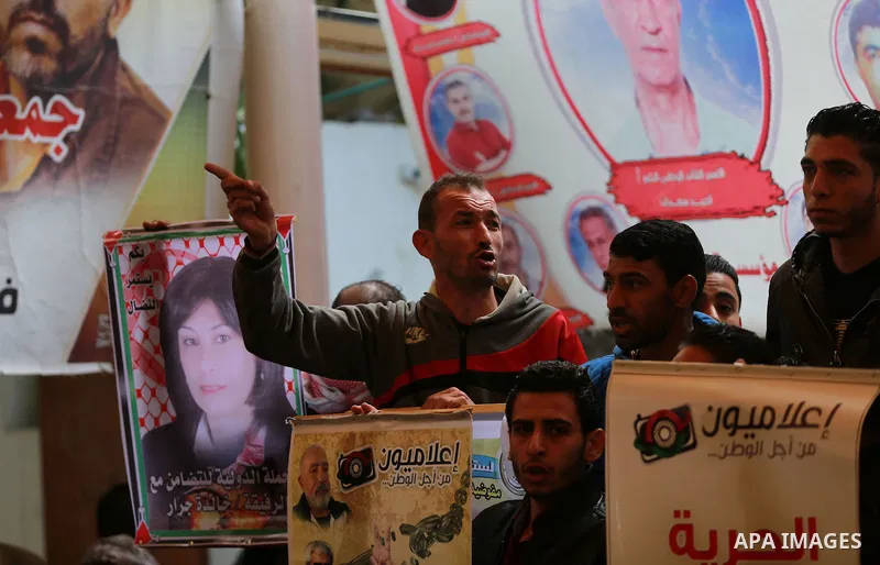 Palestinians take part in a protest demanding release the prisoners in Israeli jails, in front of Red cross office, in Gaza city, on March 14, 2016. Photo by Yasser Qudih