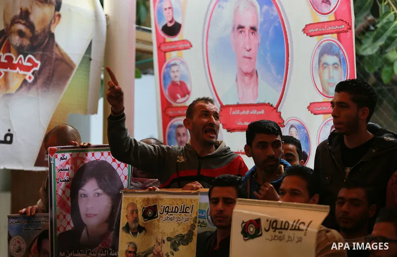 Palestinians take part in a protest demanding release the prisoners in Israeli jails, in front of Red cross office, in Gaza city, on March 14, 2016. Photo by Yasser Qudih
