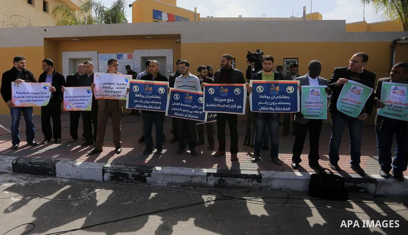Palestinian journalists hold placards during a protest to solidarity with al-Aqsa TV channel which it removing from EUTELSAT, in Gaza City on March 14, 2016. Israeli Prime Minister Benjamin Netanyahu said Sunday that Isr...