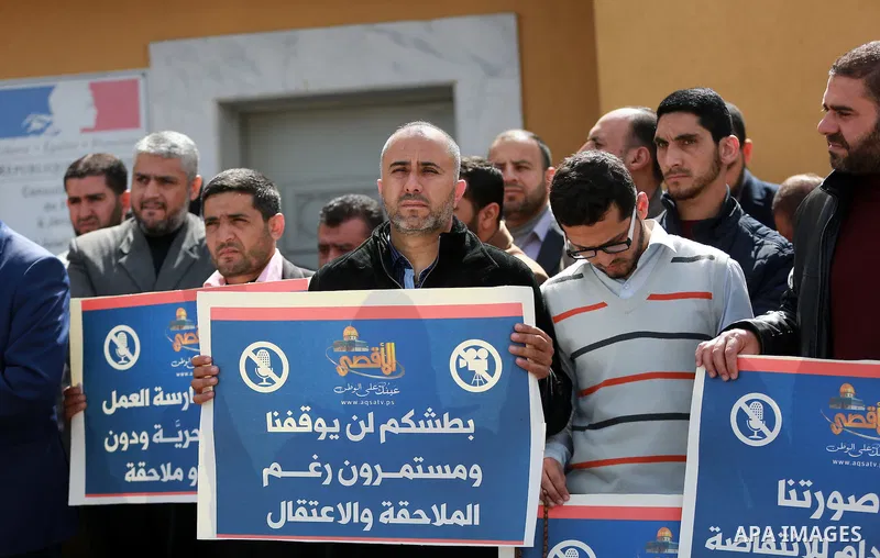 Palestinian journalists hold placards during a protest to solidarity with al-Aqsa TV channel which it removing from EUTELSAT, in Gaza City on March 14, 2016. Israeli Prime Minister Benjamin Netanyahu said Sunday that Isr...