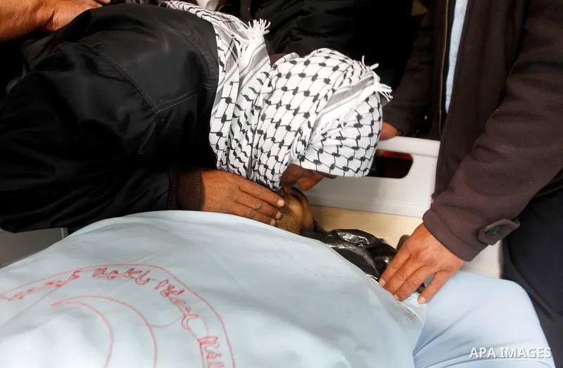 Mourners gather around the body of one of three Palestinians, who the Israeli military said were shot dead by the Israeli army after they carried out attacks on Israelis, in a hospital in the West Bank city of Hebron Mar...