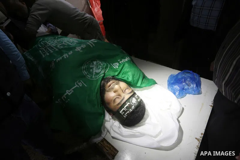 Palestinians mourn around the body of Ezzedine al-Qassam Brigades member Abdel Salam Al-Batniji, 36, during his funeral Gaza city, on March 14, 2016. A Gaza tunnel collapsed in Shujaiyyeh, in the eastern part of Gaza cit...