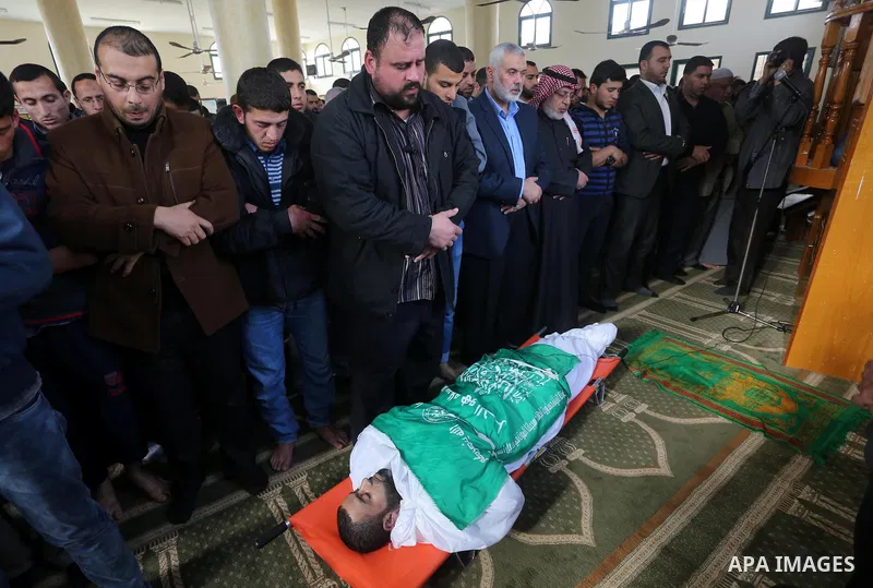 Palestinians pray in front of the body of Ezzedine al-Qassam Brigades member Abdel Salam Al-Batniji, 36,in Gaza city, on March 14, 2016. A Gaza tunnel collapsed in Shujaiyyeh, in the eastern part of Gaza city on Monday,...