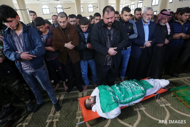Palestinians pray in front of the body of Ezzedine al-Qassam Brigades member Abdel Salam Al-Batniji, 36,in Gaza city, on March 14, 2016. A Gaza tunnel collapsed in Shujaiyyeh, in the eastern part of Gaza city on Monday,...