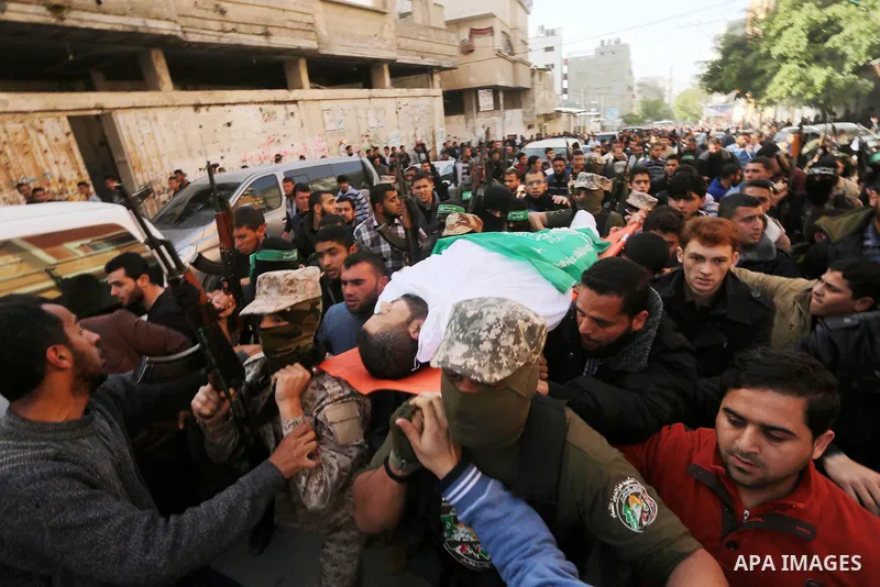 Palestinian members of the Ezzedine al-Qassam Brigades, the armed wing of the Hamas movement carry the body of their comrade Abdel Salam Al-Batniji, 36, during his funeral Gaza city, on March 14, 2016. A Gaza tunnel coll...