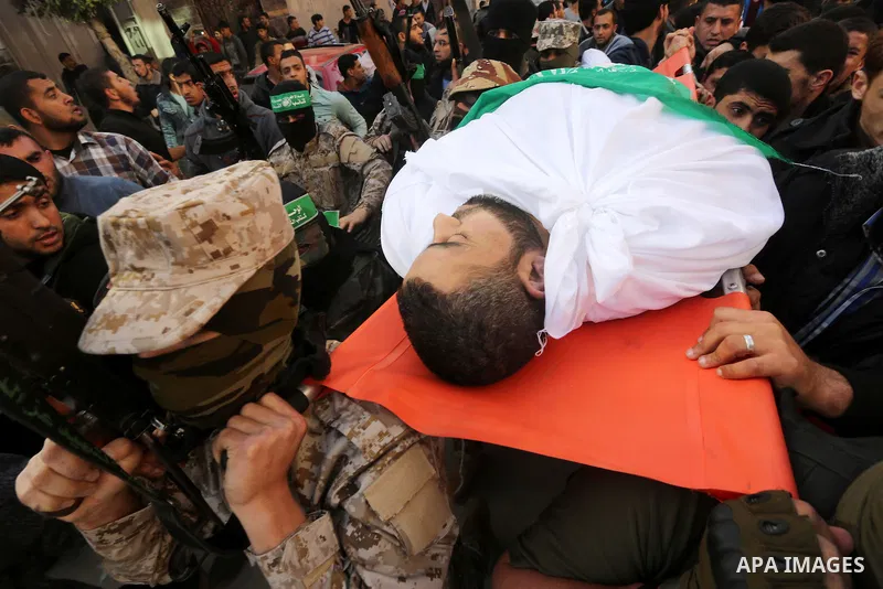Palestinian members of the Ezzedine al-Qassam Brigades, the armed wing of the Hamas movement carry the body of their comrade Abdel Salam Al-Batniji, 36, during his funeral Gaza city, on March 14, 2016. A Gaza tunnel coll...
