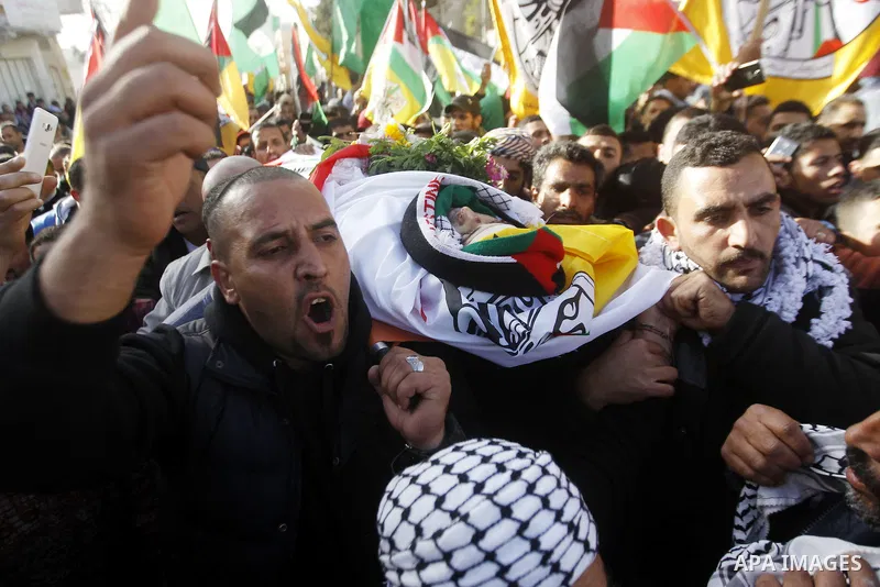 Mourners carry the body of Palestinian Yousef Tarayra, 18, who the Israeli military said was shot dead by the Israeli army after he carried out an attack on Israelis, during his funeral in the West Bank village of Bani N...