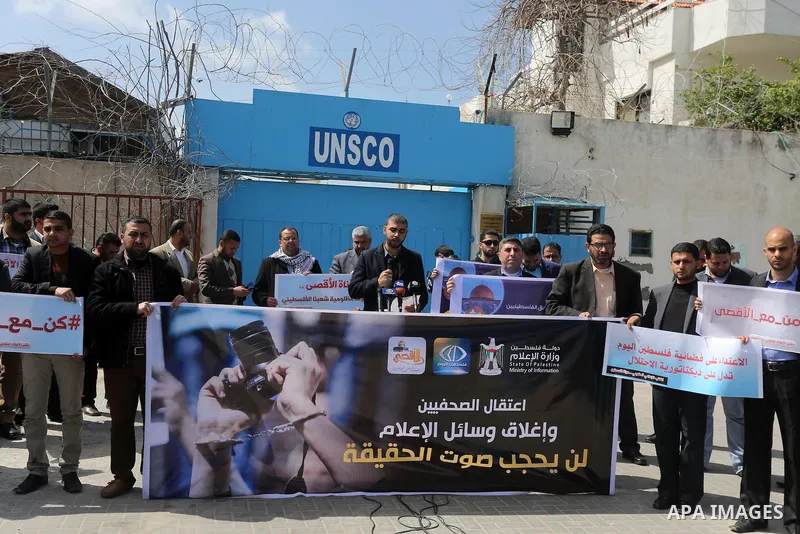 Palestinian employees of Al-Aqsa TV carry placards during a protest outside the United Nations Office in Gaza City on March 15, 2016, against the decision to halt transmission of the channel by the French satellite Eutel...
