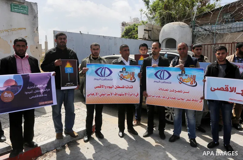 Palestinian employees of Al-Aqsa TV carry placards during a protest outside the United Nations Office in Gaza City on March 15, 2016, against the decision to halt transmission of the channel by the French satellite Eutel...