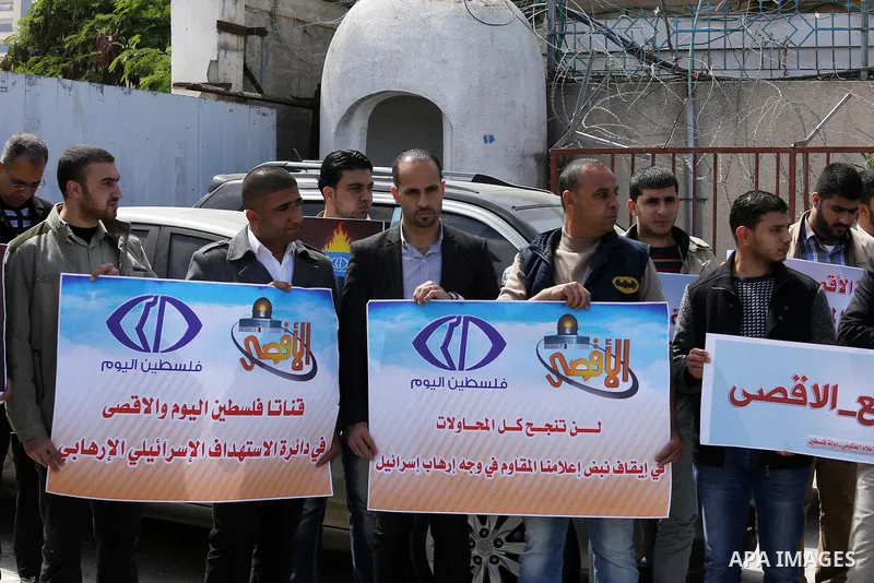 Palestinian employees of Al-Aqsa TV carry placards during a protest outside the United Nations Office in Gaza City on March 15, 2016, against the decision to halt transmission of the channel by the French satellite Eutel...