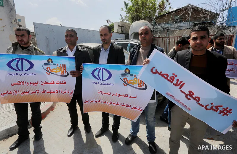 Palestinian employees of Al-Aqsa TV carry placards during a protest outside the United Nations Office in Gaza City on March 15, 2016, against the decision to halt transmission of the channel by the French satellite Eutel...