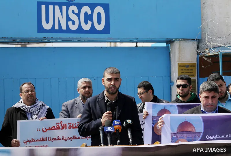 Palestinian employees of Al-Aqsa TV carry placards during a protest outside the United Nations Office in Gaza City on March 15, 2016, against the decision to halt transmission of the channel by the French satellite Eutel...