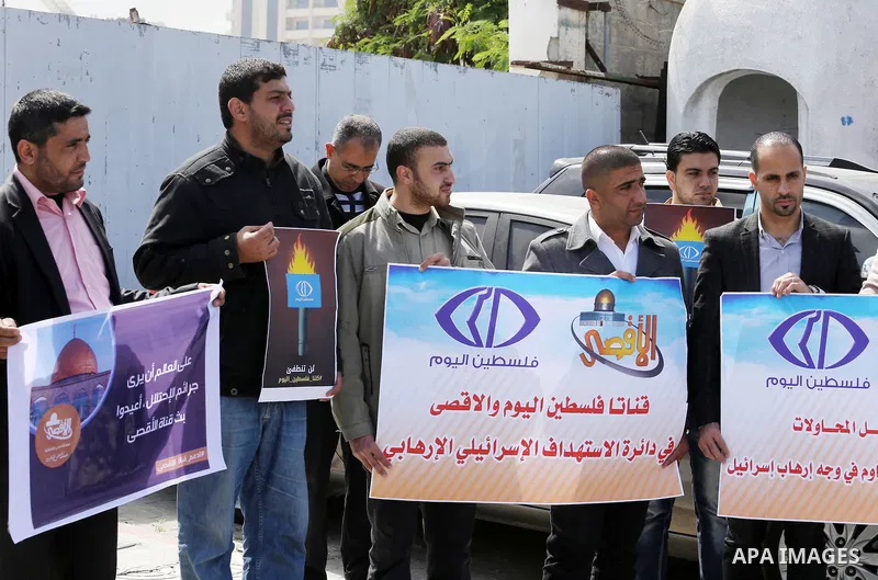 Palestinian employees of Al-Aqsa TV carry placards during a protest outside the United Nations Office in Gaza City on March 15, 2016, against the decision to halt transmission of the channel by the French satellite Eutel...