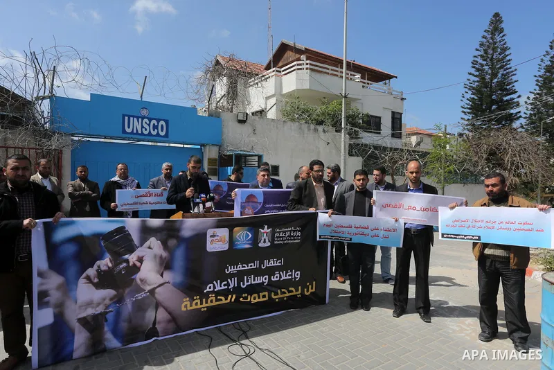 Palestinian employees of Al-Aqsa TV carry placards during a protest outside the United Nations Office in Gaza City on March 15, 2016, against the decision to halt transmission of the channel by the French satellite Eutel...