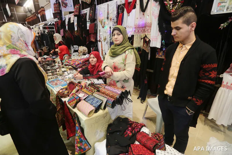 Palestinian women take part during Palestinian Heritage Exhibition on the theme ''Products of our women'', in Gaza City, on March 15, 2016. Photo by Mohammed Asad