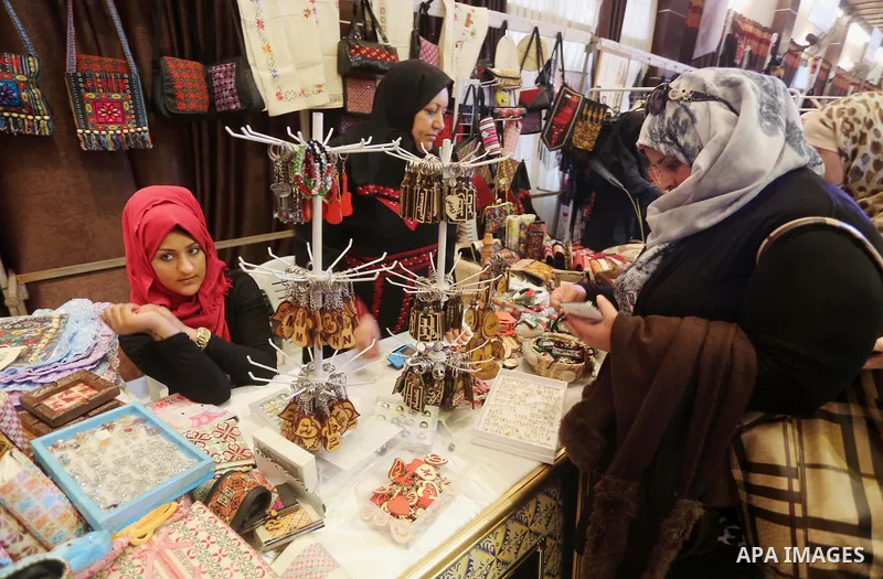 Palestinian women take part during Palestinian Heritage Exhibition on the theme ''Products of our women'', in Gaza City, on March 15, 2016. Photo by Mohammed Asad