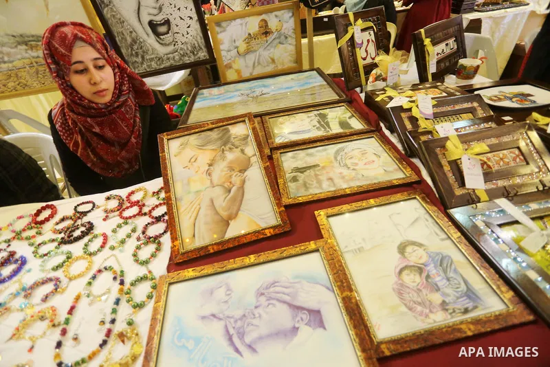 Palestinian women take part during Palestinian Heritage Exhibition on the theme ''Products of our women'', in Gaza City, on March 15, 2016. Photo by Mohammed Asad